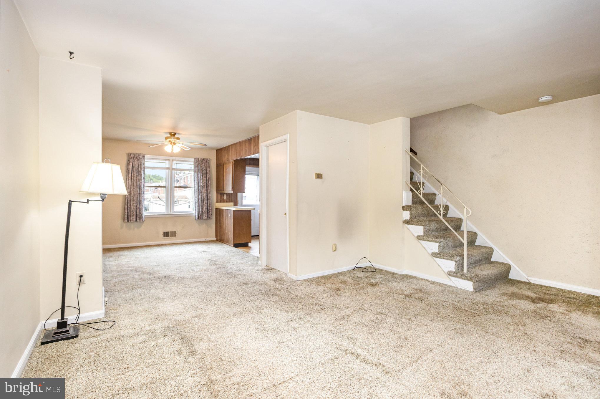 104 Bladen Road Baltimore, MD 21221 - Photo 3 of 16 a view of a livingroom with wooden floor and stairs