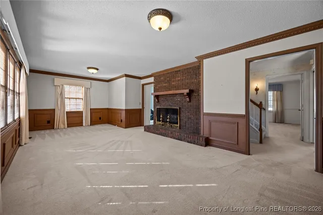 a big room with fireplace and a window