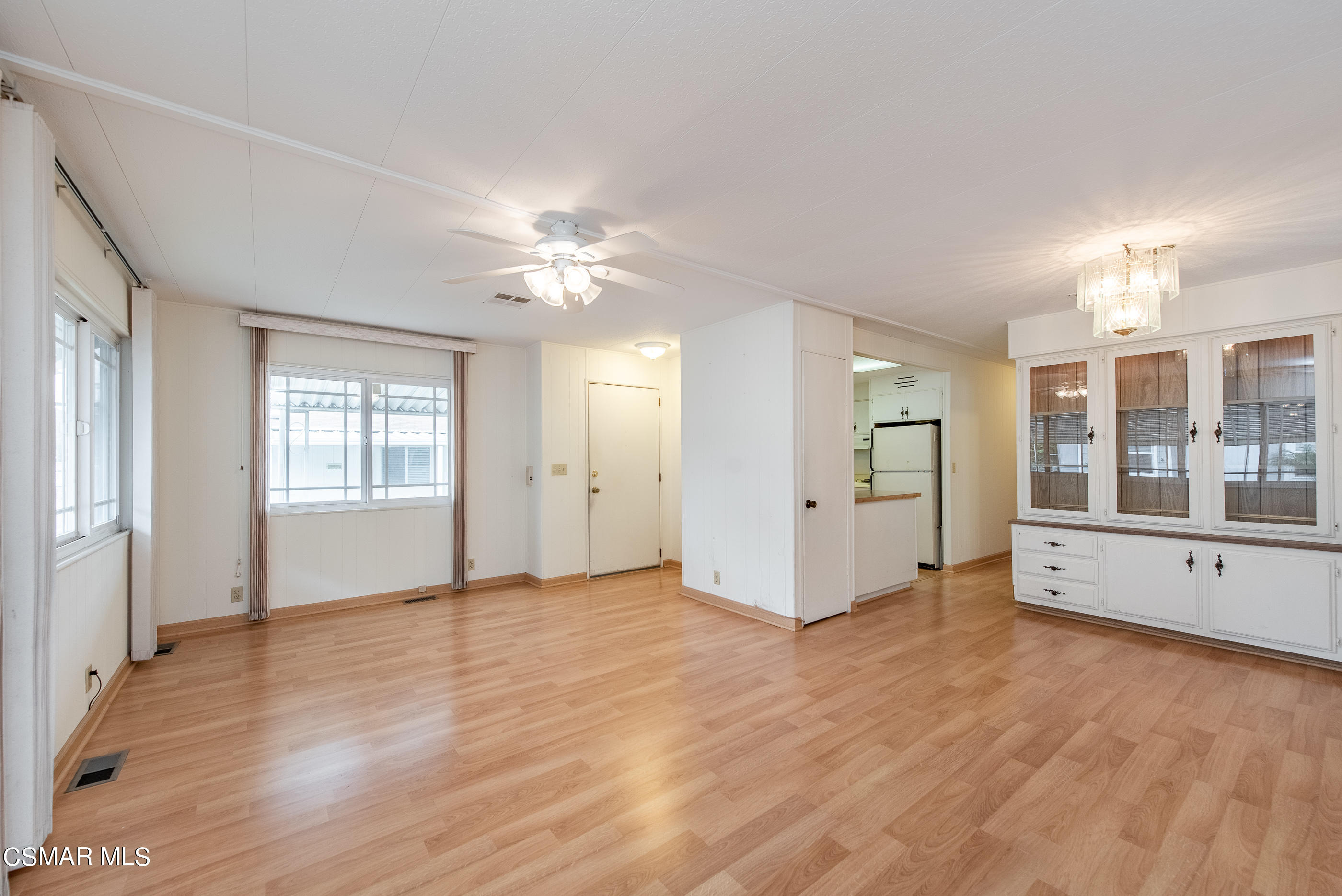 a view of an empty room with window and wooden floor