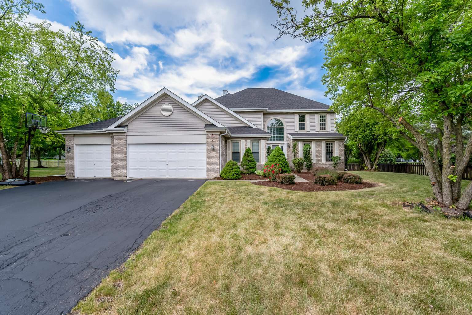 a front view of a house with a yard and trees