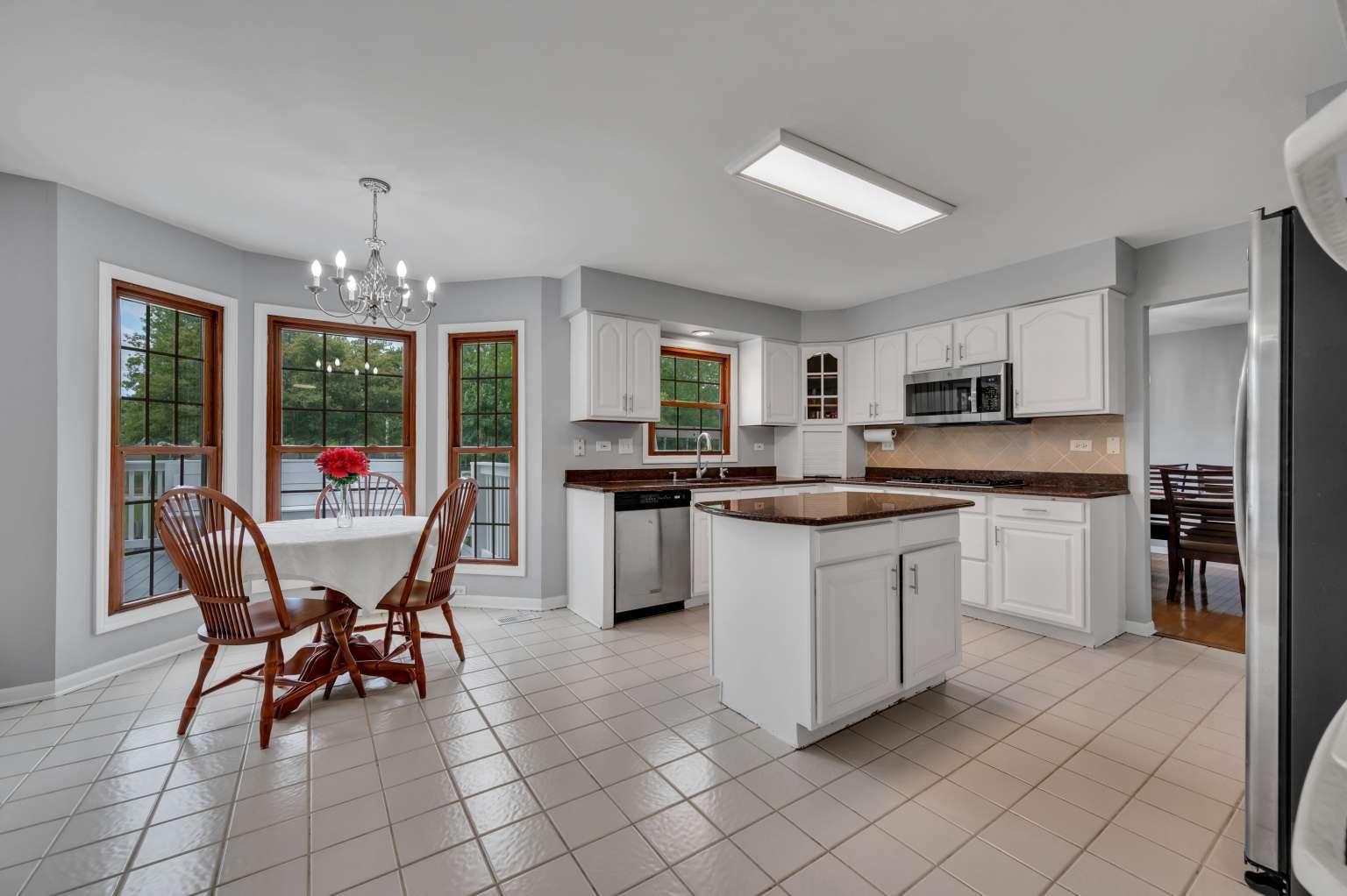 1113 Stonegate Court Bartlett, IL 60103 - Photo 8 of 25 a kitchen with a table chairs refrigerator and cabinets