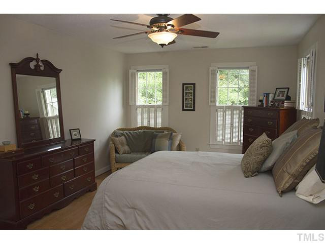 21 Swallows Ridge Court Durham, NC 27713 - Photo 17 of 25 a bedroom with a bed and a chandelier