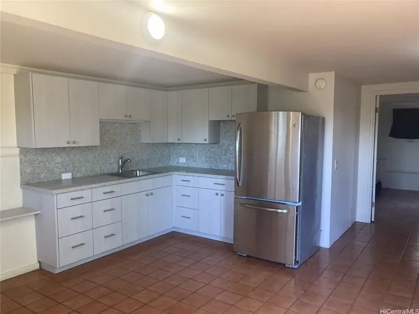 a kitchen with stainless steel appliances granite countertop a refrigerator and a stove top oven