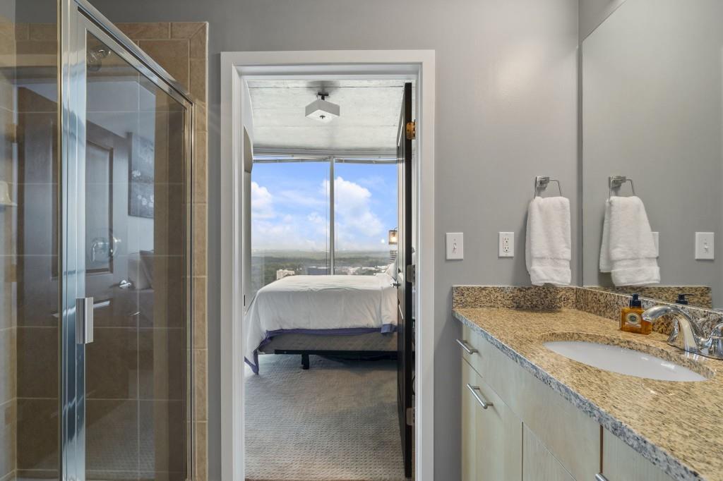 3324 Peachtree Road Northeast, Unit 2918 Atlanta, GA 30326 - Photo 14 of 27 a en suite bathroom with a granite countertop sink and a mirror