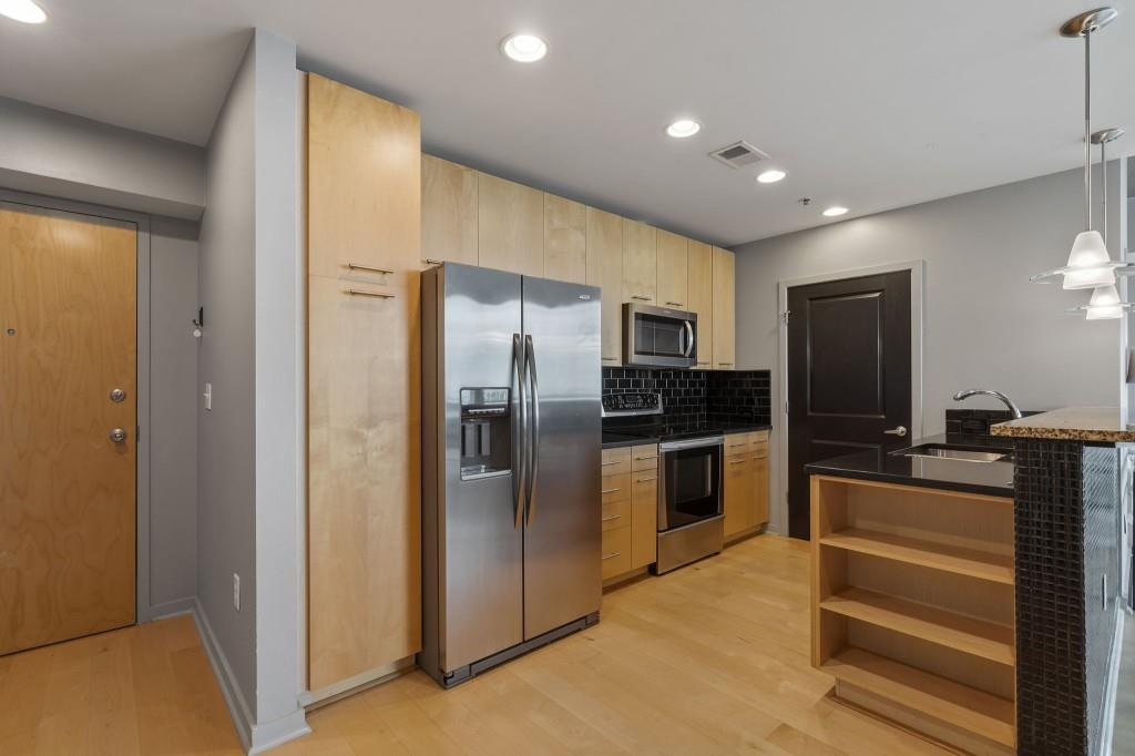3324 Peachtree Road Northeast, Unit 2918 Atlanta, GA 30326 - Photo 2 of 27 a kitchen with stainless steel appliances kitchen island granite countertop a refrigerator and a sink