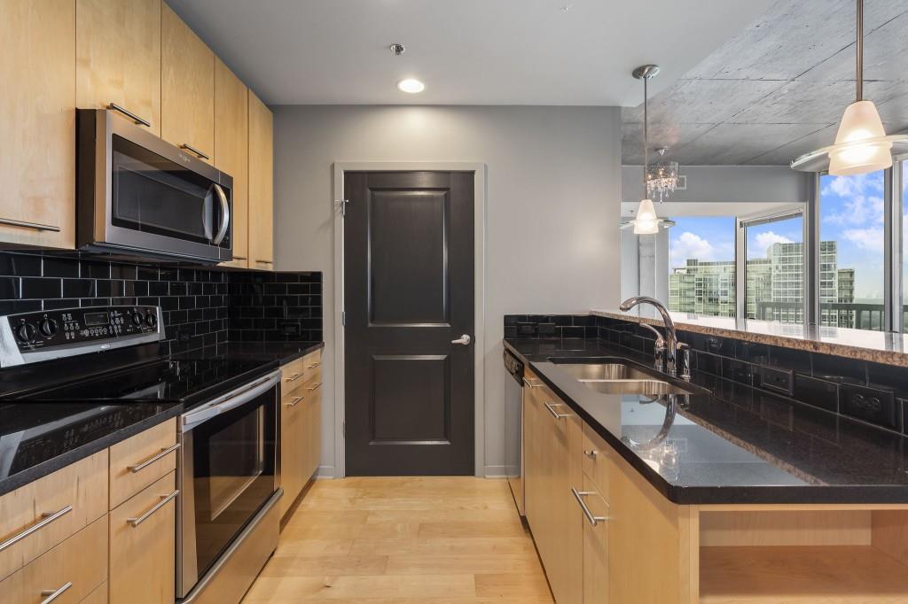 3324 Peachtree Road Northeast, Unit 2918 Atlanta, GA 30326 - Photo 4 of 27 a kitchen with granite countertop a sink stove and microwave
