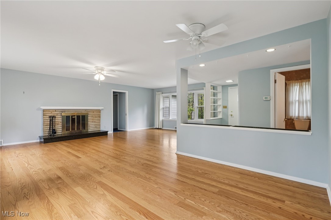 33300 South Woodland Road Cleveland, OH 44124 - Photo 13 of 50 Unfurnished living room featuring wood finished floors, a glass covered fireplace, recessed lighting, and ceiling fan