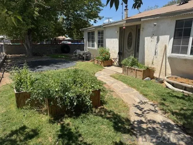 a view of a chair and table in backyard of the house