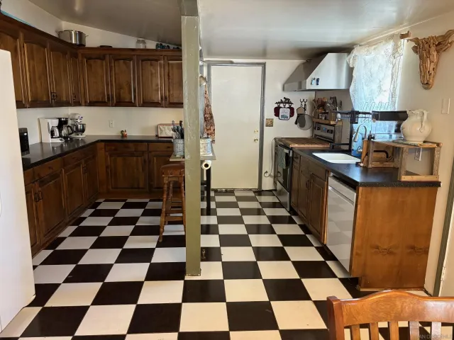 a kitchen with a checkered floor and white cabinets with a black white checkered floor