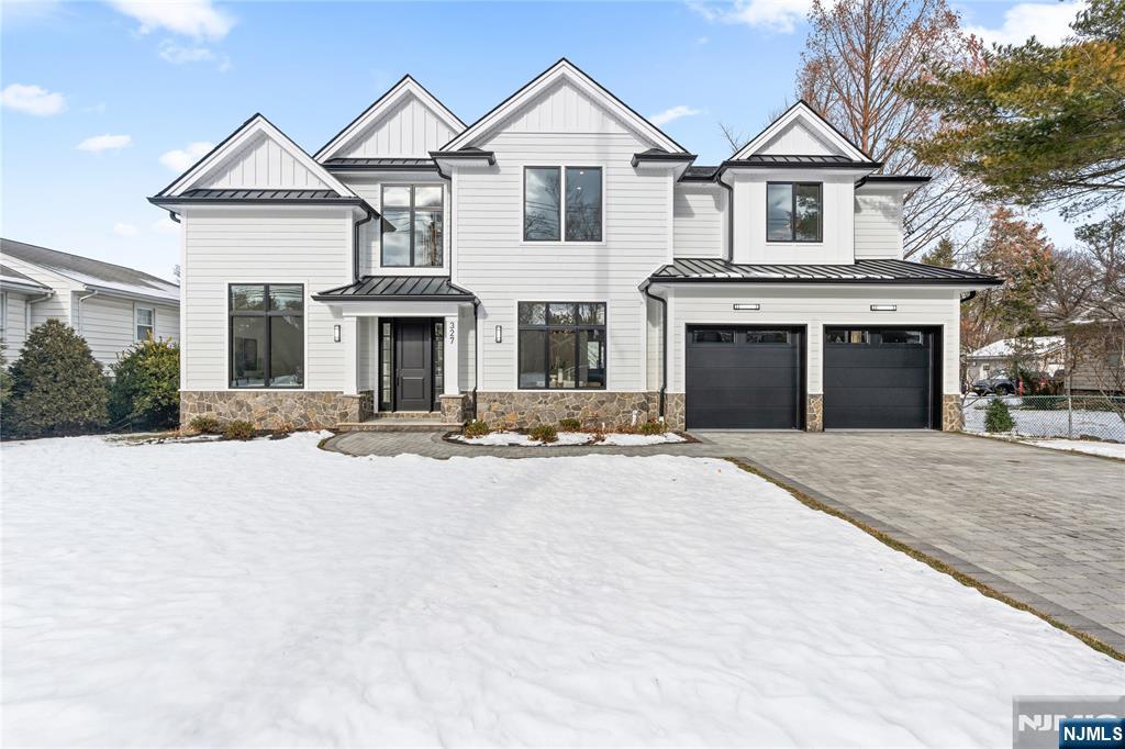 a front view of a house with yard and parking
