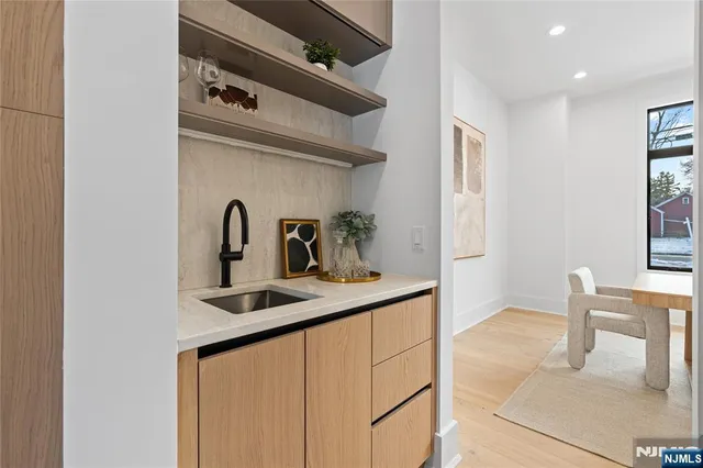 a kitchen with sink a faucet and chairs