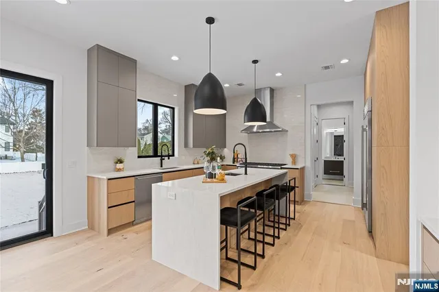 a view of a kitchen with kitchen island a sink stainless steel appliances and a counter top