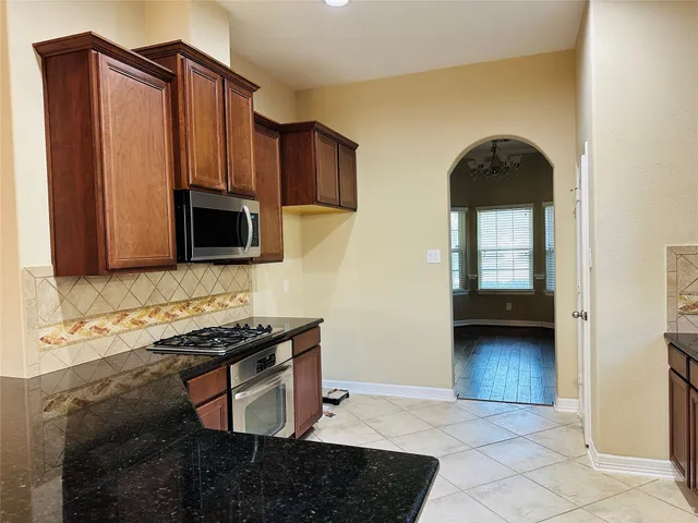a kitchen with stainless steel appliances a stove microwave and cabinets
