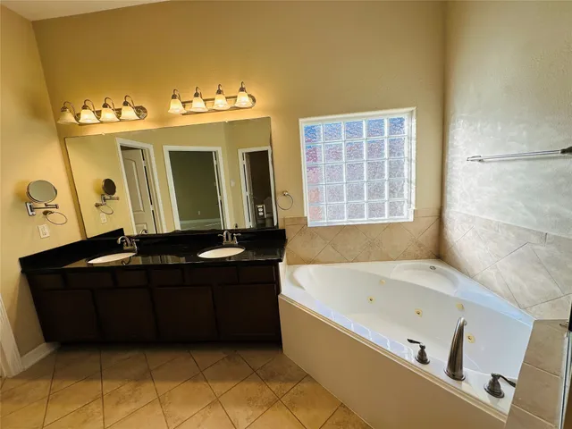 a spacious bathroom with a sink and a mirror