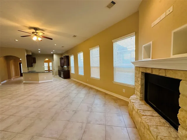 a view of an empty room with a fireplace and a fan