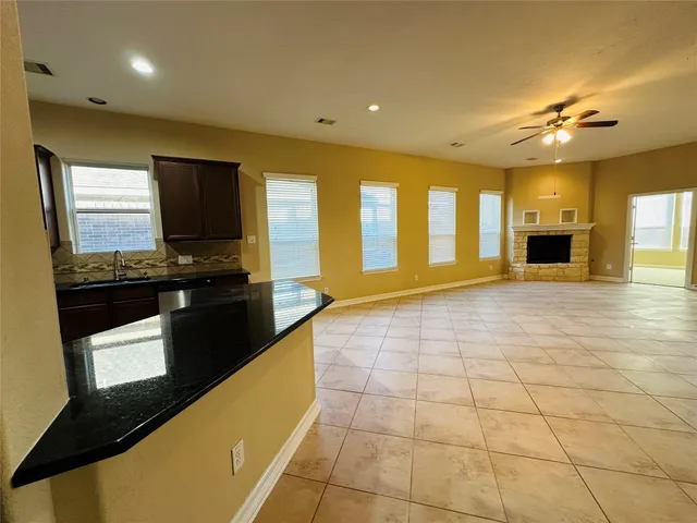 a kitchen with stainless steel appliances granite countertop a stove and a view of living room