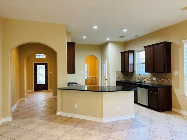 a large kitchen with stainless steel appliances granite countertop a stove and a sink