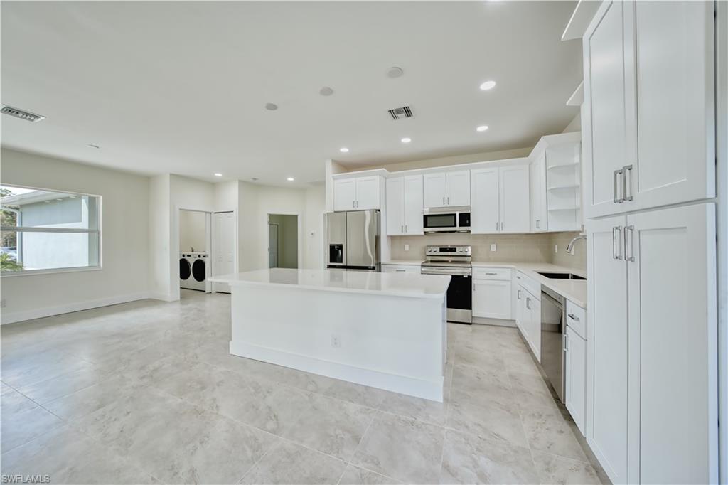 a large white kitchen with white cabinets