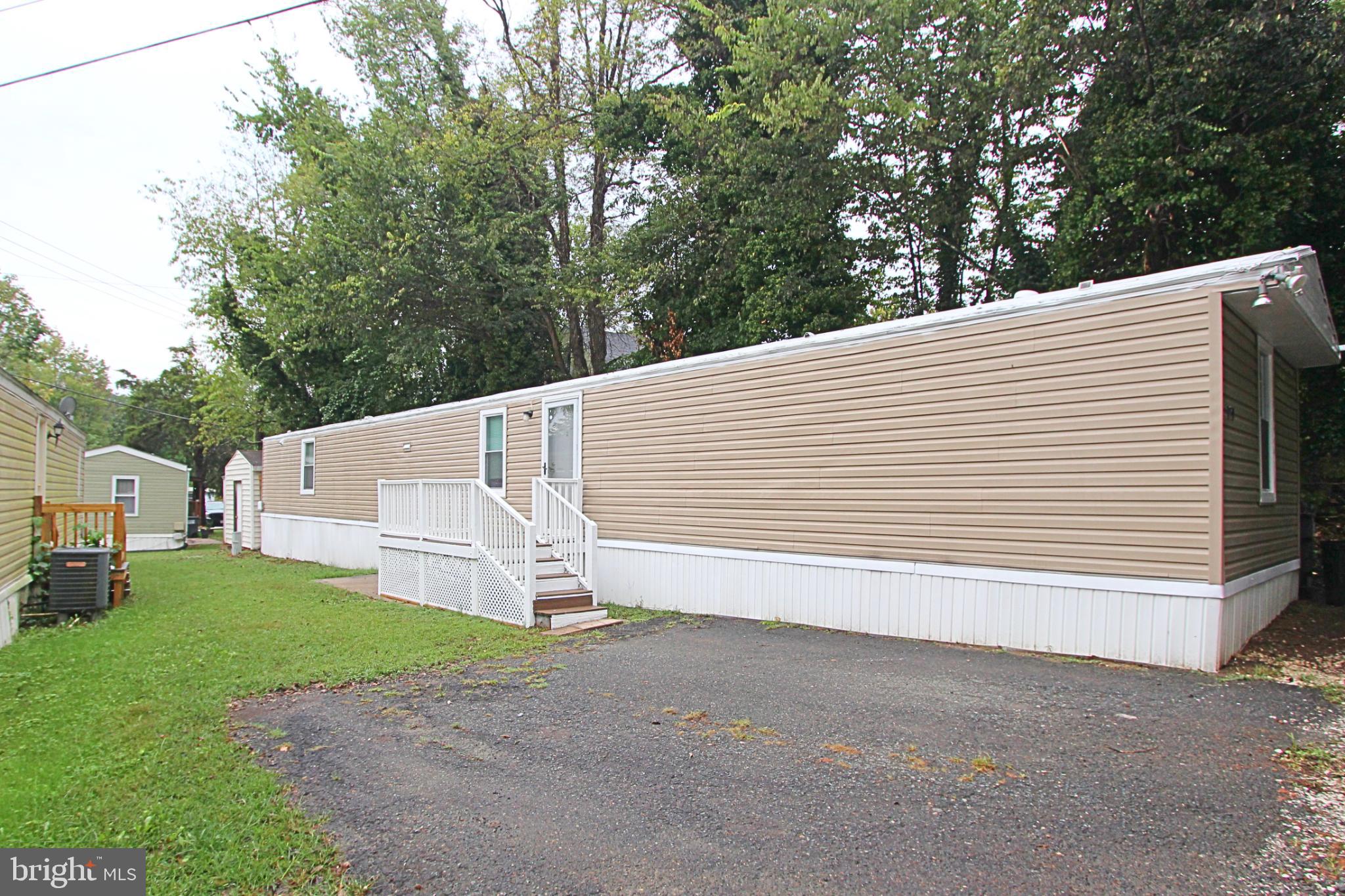 a view of a white house with a yard and large tree