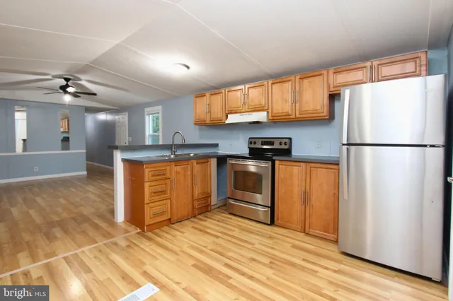 a kitchen with granite countertop a refrigerator a sink and dishwasher