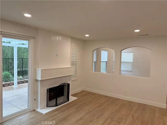 an empty room with windows and fireplace