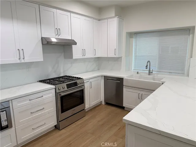 a kitchen with cabinets appliances a sink and a stove