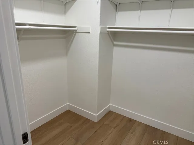 an empty room with wooden floor and mirror