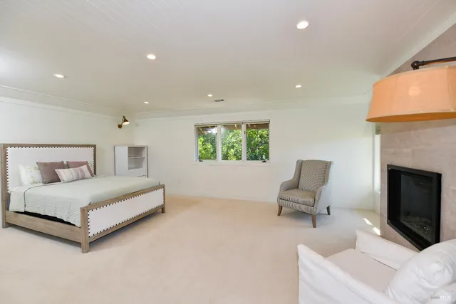 a spacious bedroom with a bed and a chair