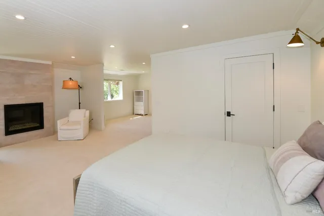 a spacious bedroom with a bed a fireplace and a couch