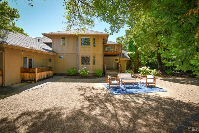 a backyard of a house with table and chairs