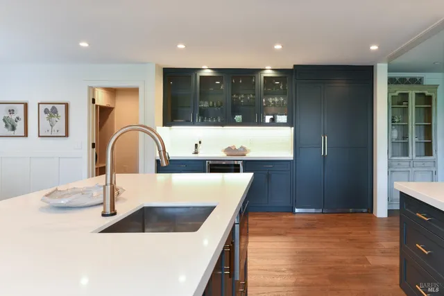 a kitchen with kitchen island a sink and a refrigerator