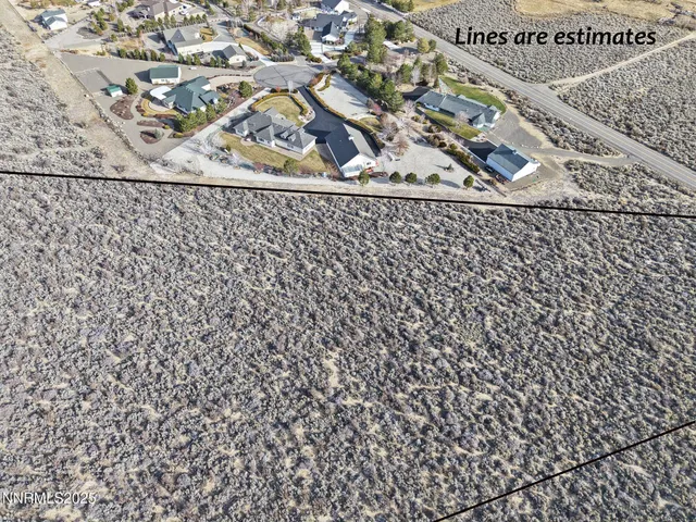 a view of a dry yard with mountains in the background