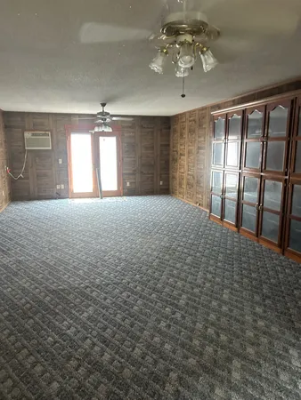 en empty room with windows and ceiling fan