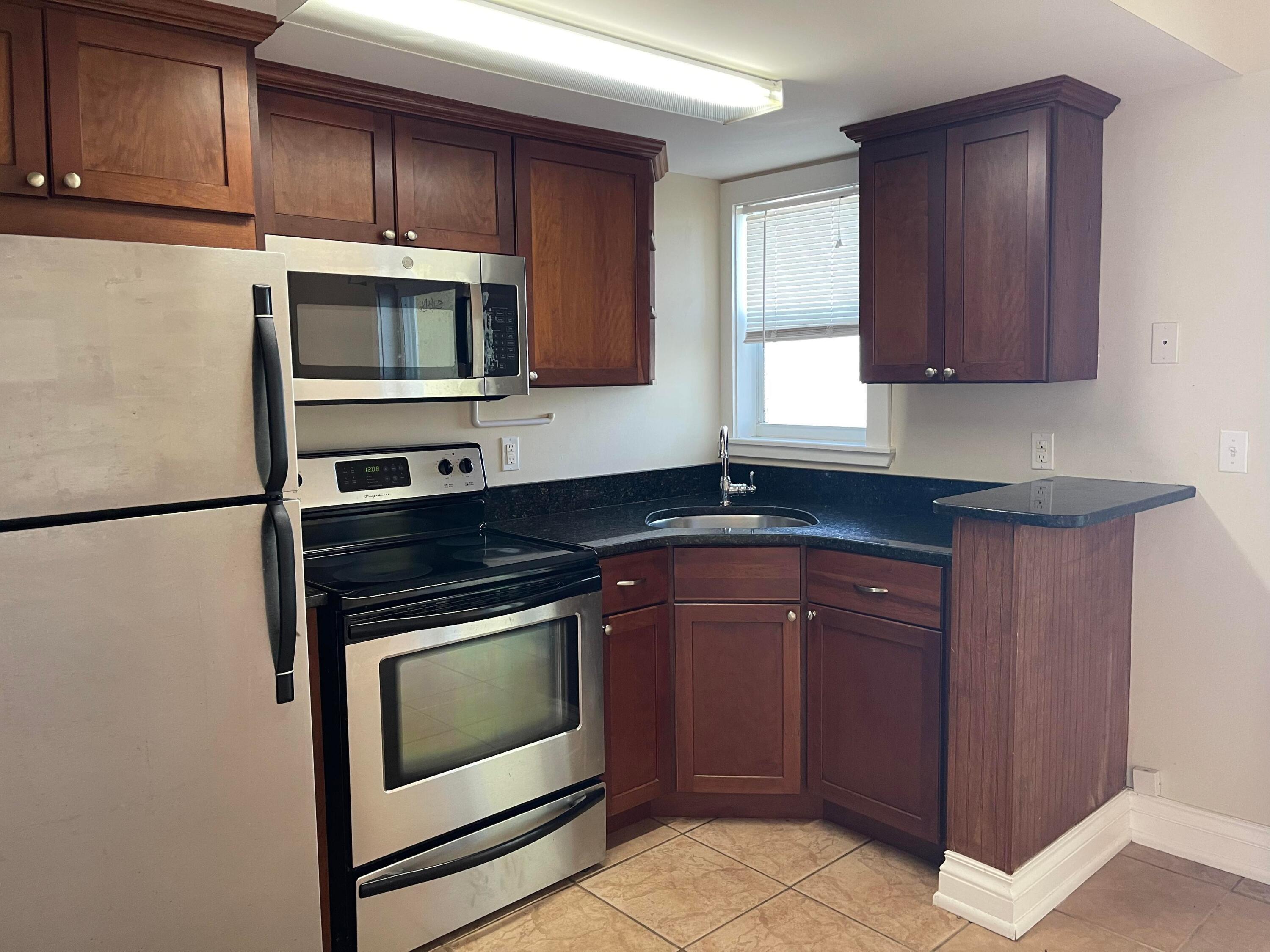 201 Coppitt Road, Unit 104B Key West, FL 33040 - Photo 3 of 13 a kitchen with granite countertop cabinets stainless steel appliances and counter space