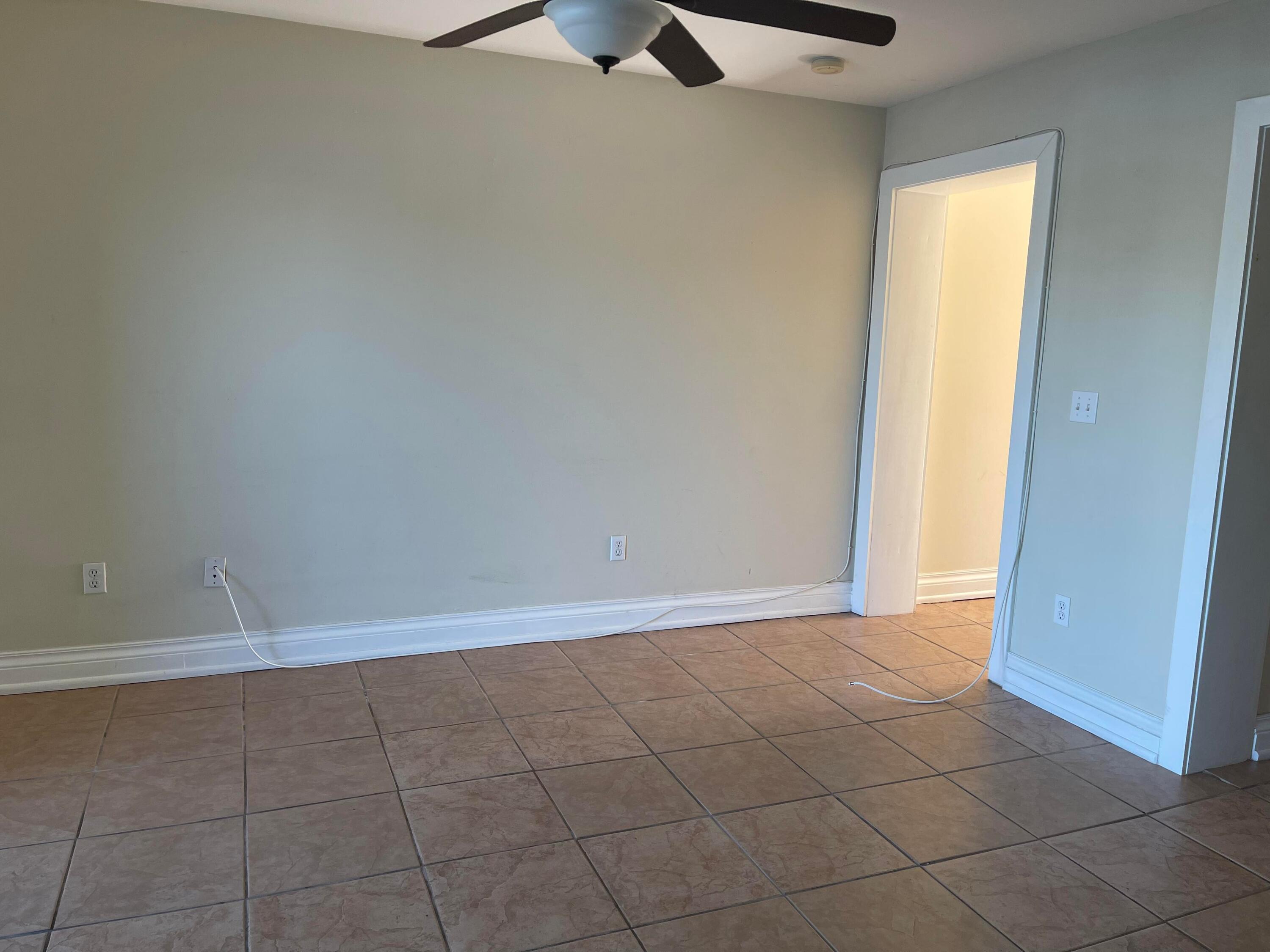 201 Coppitt Road, Unit 104B Key West, FL 33040 - Photo 5 of 13 an empty room with a ceiling fan and carpet