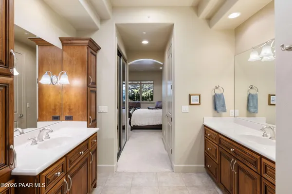 a en suite bathroom with a double vanity sink a large mirror and a shower