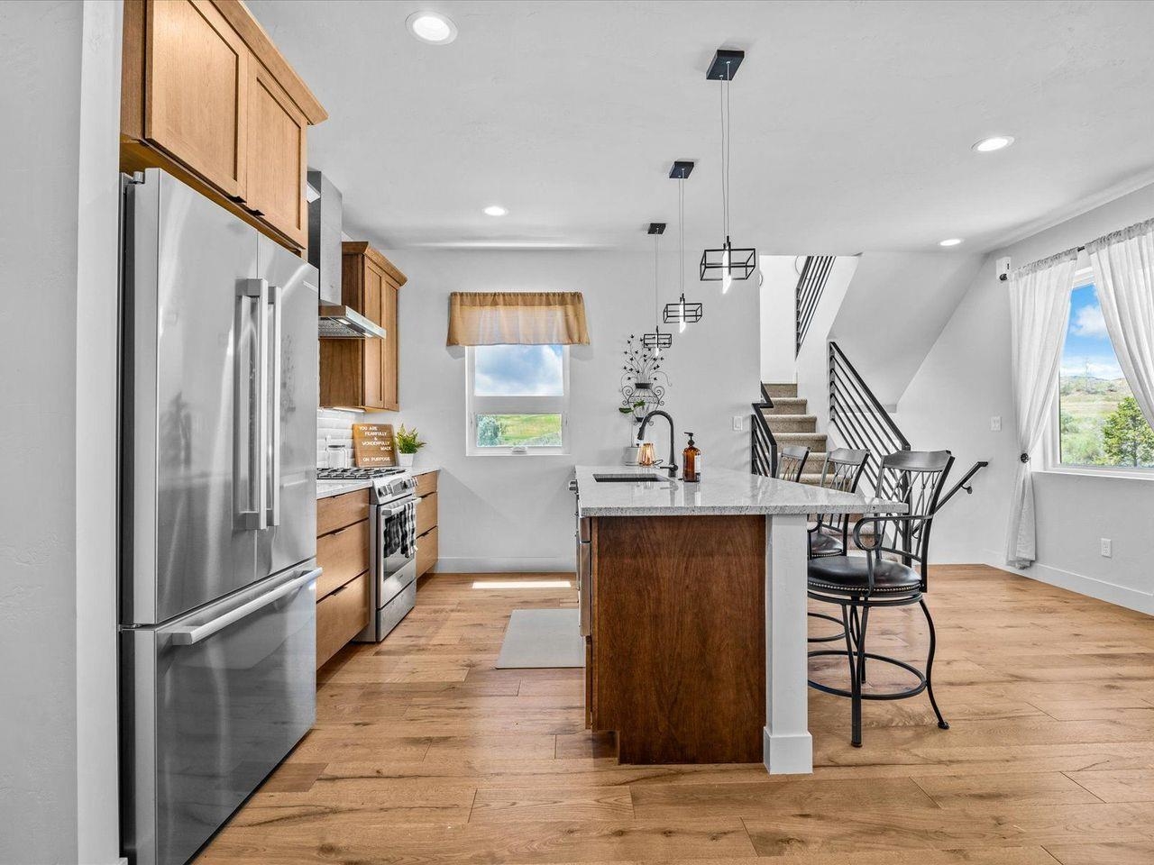 365 West Ridges Boulevard, Unit A Grand Junction, CO 81507 - Photo 13 of 42 a kitchen with stainless steel appliances kitchen island granite countertop a refrigerator a stove and a wooden floors