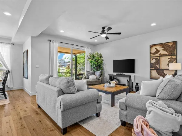 a kitchen with stainless steel appliances kitchen island granite countertop a refrigerator a stove and a wooden floors