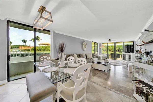 a living room with furniture large windows and wooden floor