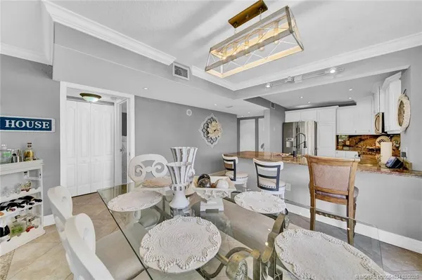 a dining room with furniture a rug and white walls