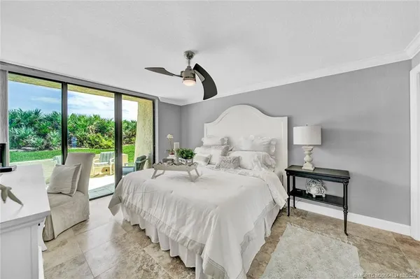 a bedroom with a bed a large window and walk in closet