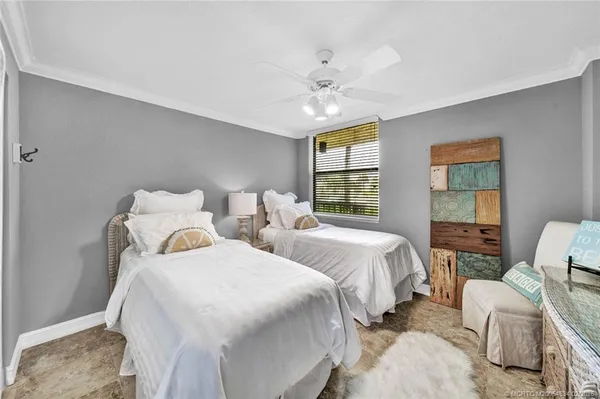 a bedroom with two beds and painting on the wall