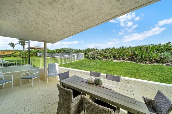 a view of a patio with a table chairs and a yard