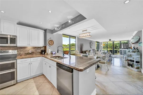 a kitchen with lots of counter top space sink dining table and chairs