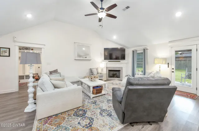 a living room with furniture a fireplace and a flat screen tv