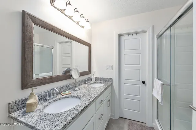 a bathroom with a granite countertop sink and a mirror