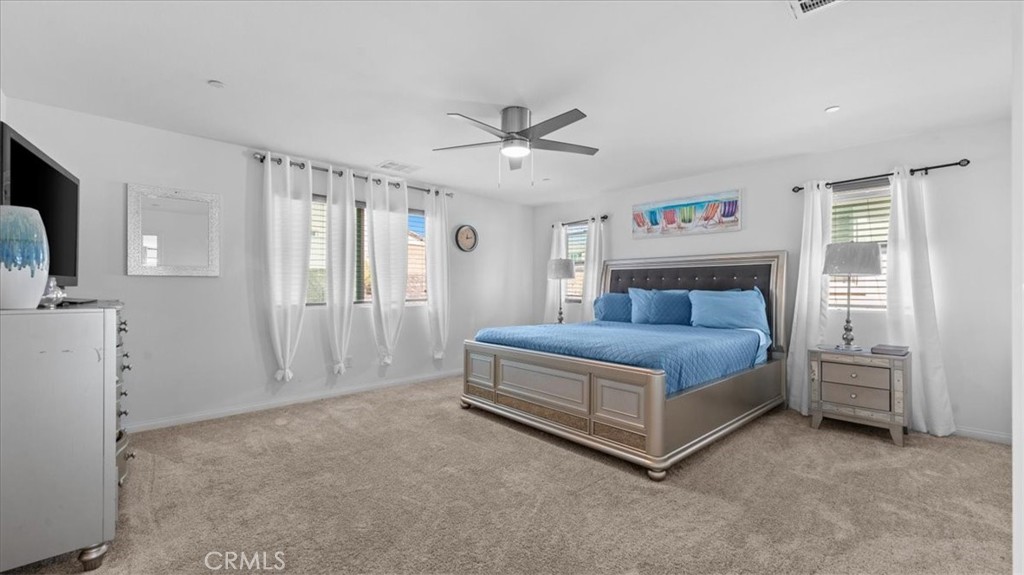 35580 Roxy Road Beaumont, CA 92223 - Photo 14 of 39 a spacious bedroom with a bed and a ceiling fan