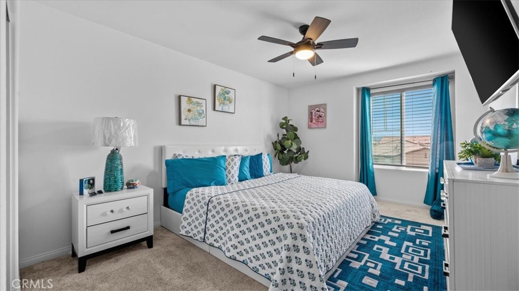 35580 Roxy Road Beaumont, CA 92223 - Photo 19 of 39 a bedroom with a large bed and a chandelier