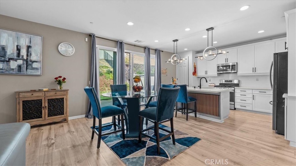 35580 Roxy Road Beaumont, CA 92223 - Photo 6 of 39 a kitchen with stainless steel appliances kitchen island granite countertop a stove a refrigerator a oven a sink with a dining table and chairs