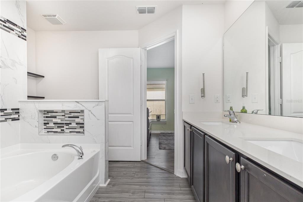 1760 Canaan Loop Dundee, FL 33838 - Photo 16 of 25 a bathroom with a tub sink and mirror